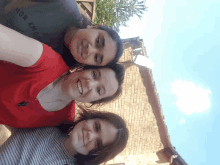 three women are posing for a picture with one wearing a mon amour shirt