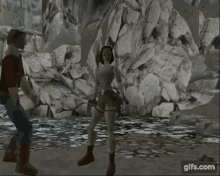 a woman is standing next to a man in a video game in front of a large rock .