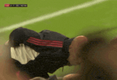a soccer player is laying on the field with a score of 2 to 1