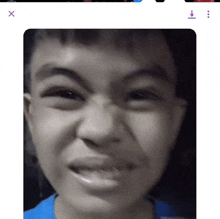 a close up of a young boy making a funny face on a phone screen .