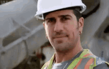 a man wearing a hard hat and safety vest is smiling for the camera with the slice logo in the background