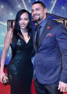 roman reigns and his wife pose for a photo on the red carpet