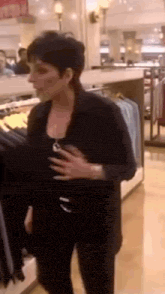 a woman in a black jacket is standing in a store