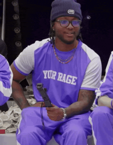 a man wearing a purple shirt that says yor rage