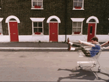 a man in a shopping cart is being pushed by another person