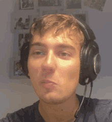 a young man wearing headphones and a microphone making a funny face