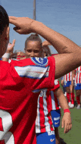 a group of female soccer players are standing on a field and one of them has the number 2 on her shirt