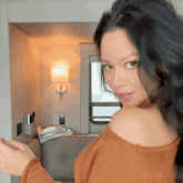 a woman wearing a brown sweater has the hashtag #mynakedthings on her shoulder