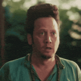a man in a blue shirt is making a surprised face with his mouth wide open