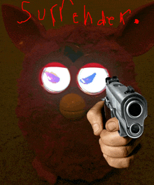 a person is pointing a gun at a red furby with the words suffer written on it