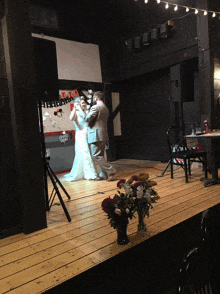 a bride and groom are dancing on a stage in front of a sign that says " love "