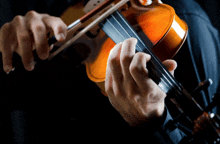 a person playing a violin with their hands on the strings