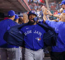 a man in a blue jays shirt is being held up by his jacket