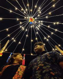 a man and a woman are looking up at a ceiling of lights