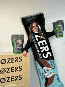 a woman holding a bar that says ozers