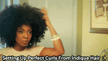 a woman brushing her hair in front of a mirror with the caption setting up perfect curls from indicue hair