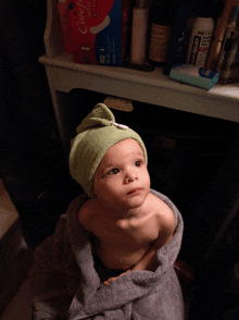 a baby wrapped in a towel is looking up at something