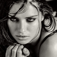 a black and white photo of a woman 's face with wet hair