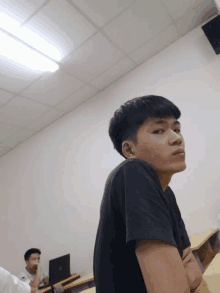 a man in a black shirt sits in a classroom