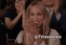 a woman applauds while sitting in a crowd with the hashtag tvresidence