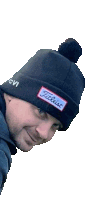 a man wearing a black beanie with a patch that says titleist on it