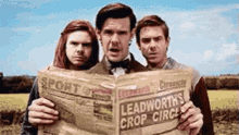 three men are reading a newspaper that says leadworth 's crop circle