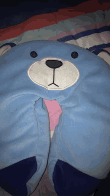 a blue teddy bear neck pillow with a black nose