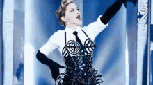 a woman in a white shirt and black tie is wearing a black corset