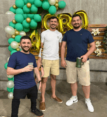 three men are posing in front of balloons that say cr