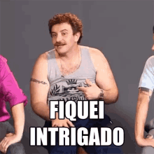 a man in a tank top says fiquei intrigado while sitting next to two other men