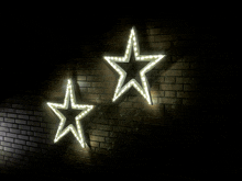 two glowing stars on a dark brick wall