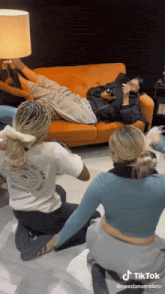 a group of people are sitting on the floor and one of them has a shirt that says needanamebro