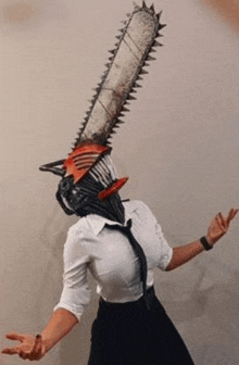 a woman in a white shirt and tie is wearing a chainsaw mask on her head .