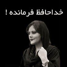 a woman wearing a scarf and a watch stands in front of a black background with arabic writing on it