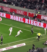 a soccer game is being played in front of a gazi banner
