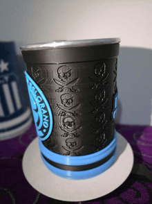 a black and blue cup with skulls and crossbones on it