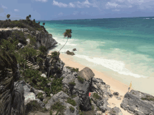 a beach with a thatched hut on the cliff