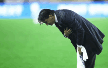 a man in a suit is kneeling down on a field