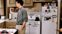 a man standing in a kitchen next to a refrigerator that has a sticker on it that says ' i love you '