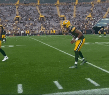 a football player in a green bay packers uniform is standing on the field