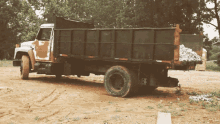 a dump truck is parked in a dirt lot and has a sticker on the back that says ' bf '