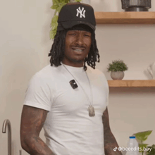 a man wearing a white shirt and a black hat with ny on it