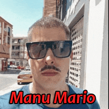 a man with a mustache is wearing sunglasses and the name manu mario is on the bottom .