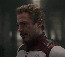 a man with a beard is wearing a white and red suit
