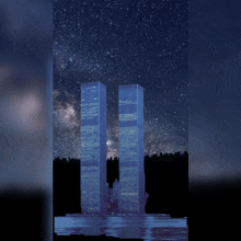 the twin towers are lit up at night with a starry sky behind them