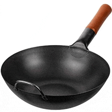 a black wok with a wooden handle on a white surface .