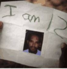 a person is holding a piece of paper that says i am 12 and has a picture of a man on it