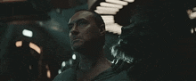 two men are standing next to each other in a dark room looking up .