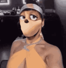 a shirtless man is wearing a cartoon character mask and a hat .