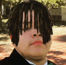 a man with dreadlocks on his head is wearing a green bow tie